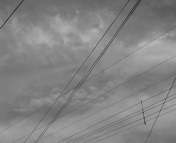 gloomy grey cloudy sky with telephone wires