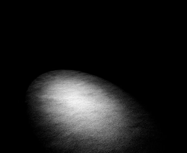 black background with one white spotlight on the bottom