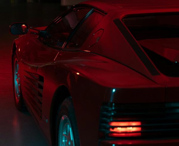 red sports car in dim lighting with tail lights on