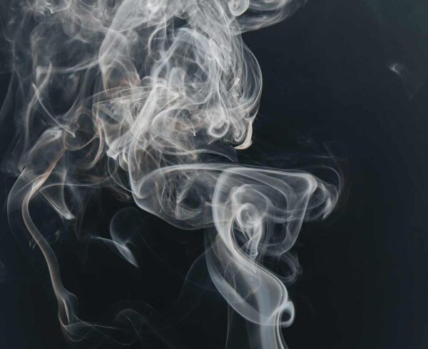 plumes of gray smoke against a black background