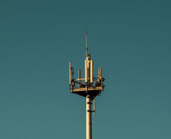 a 5g wireless tower in the air with a clear blue sky