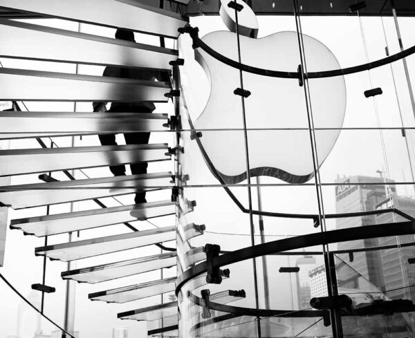 Black and white image of inside an apple store taken from under the stairs