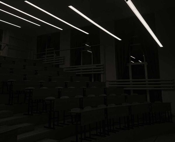 conference room in the dark with overhead lights illuminating the space