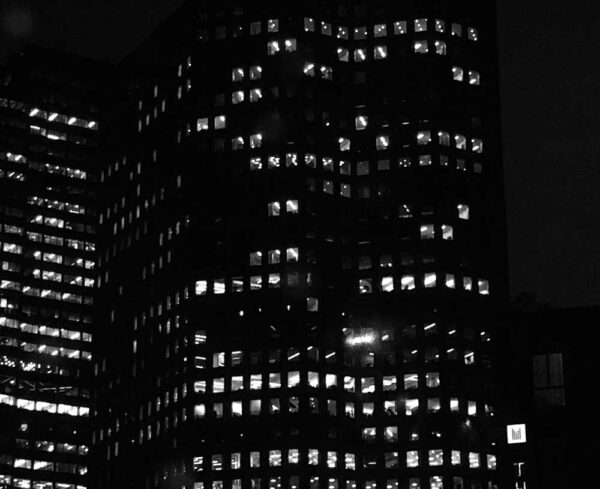 building in the dark with window lights shining through