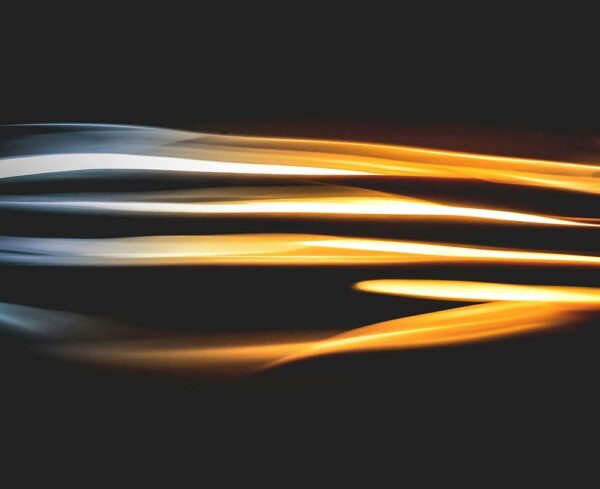 Silver and gold light lines coming through center of the darkness