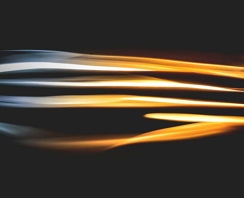 Silver and gold light lines coming through center of the darkness