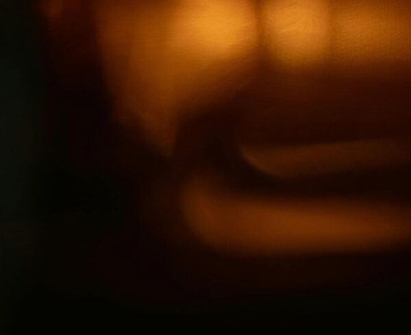 black background with orange orbs of light on the right hand side