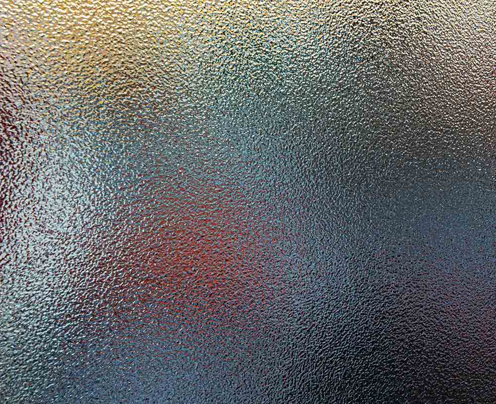 glass object covered in blurry/pixel glaze, yellow blue and red colors showing through