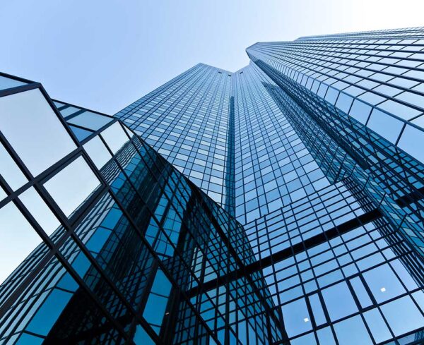 facade of building, angled upward, blue building with windows, clear blue sky