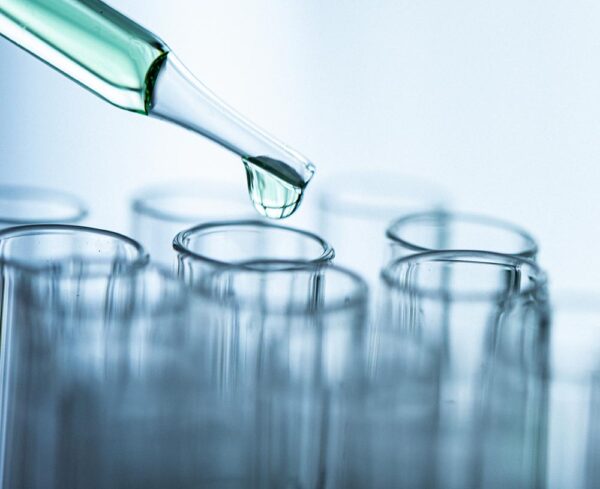 test tube dropping green liquid into other test tubes