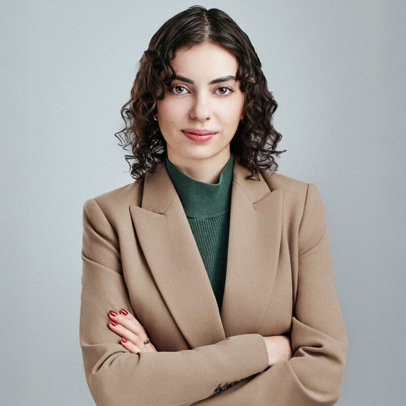 April Mihalovich looking straight into the camera with arms folded.