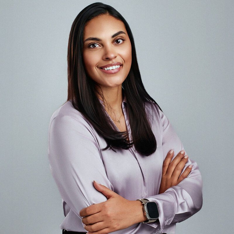 Jazlin Perez looking into the camera smiling angled to the right with arms crossed.