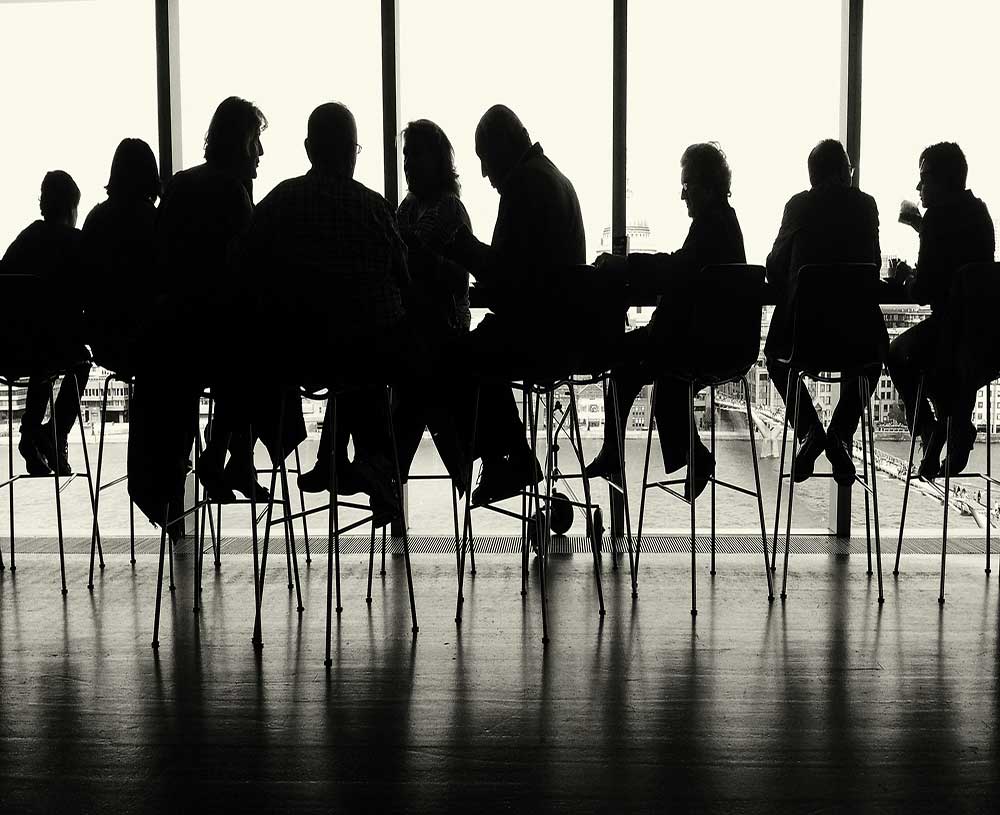 people sitting shadowed in a business like setting