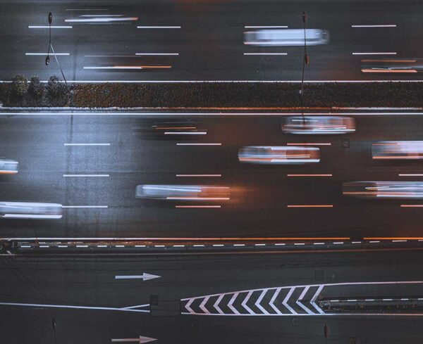 overhead view of cars speeding on road like blurs of light